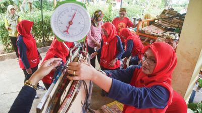 Ilustrasi - Penimbangan sampah kardus untuk di tukar dengan sembako