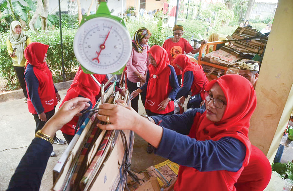 Ilustrasi - Penimbangan sampah kardus untuk di tukar dengan sembako